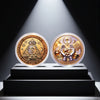 A gold commemorative coin featuring the Eye of God symbol and various monetary symbols, displayed on a dark pedestal.