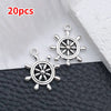 20 pieces of silver vintage ship anchor charms displayed on a black leather surface.