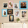 A collection of framed photographs featuring pets and couples displayed on a beige wall.
