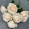 A bouquet of nine realistic pale pink silk roses arranged on a gray background.