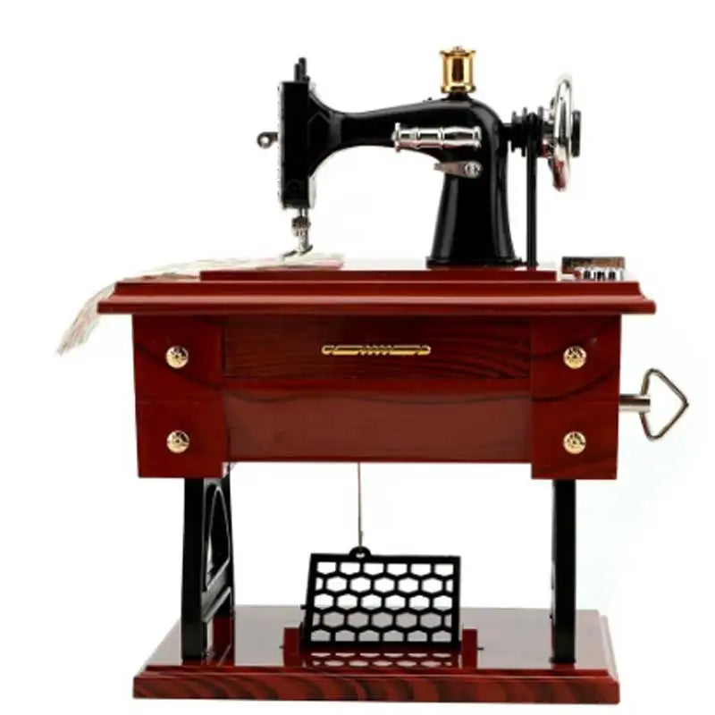 A vintage sewing machine music box decorative ornament with a black body and wooden base.
