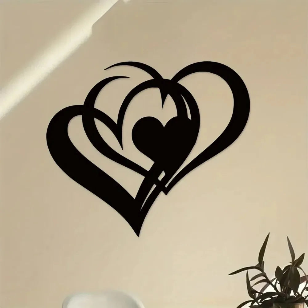 Black metal wall art featuring a stylized heart design with an inner heart silhouette on a light wall.