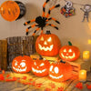 A display of glowing orange Halloween pumpkins and spooky decor, including a black spider and skeleton figures.