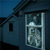 A window banner featuring multiple ghostly clown faces in a spooky Halloween theme mounted on a dark siding.