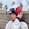 A person wearing an Iron Man-themed helmet with silver and red armor parts, posing outdoors.