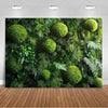 A dense backdrop of various green tropical palm leaves and spherical moss-like plants for party decor.