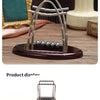 Silver Newton's cradle balance balls desktop decor featuring a metallic arch design on a wooden surface.
