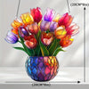 A bouquet of colorful tulips in a glass pot with a geometric pattern, hanging by a string.