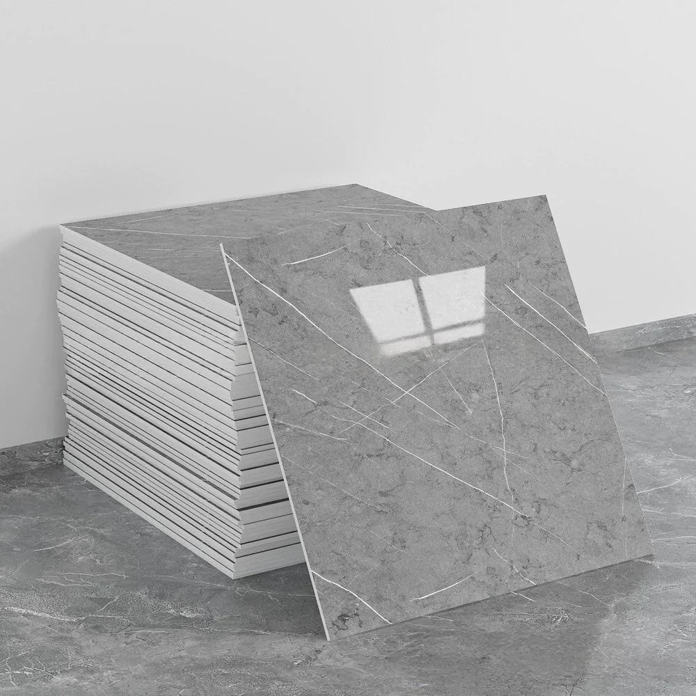 A stack of self-adhesive marble tile stickers, showing the texture and shape of the tiles.