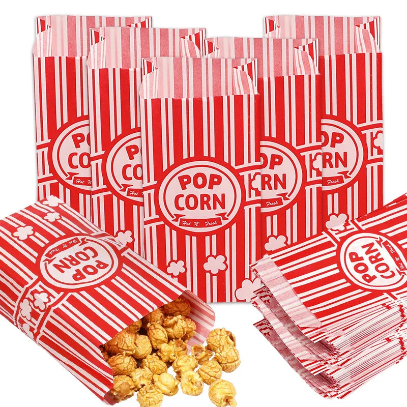 Red and white striped popcorn bags stacked and scattered, ready for parties or events.