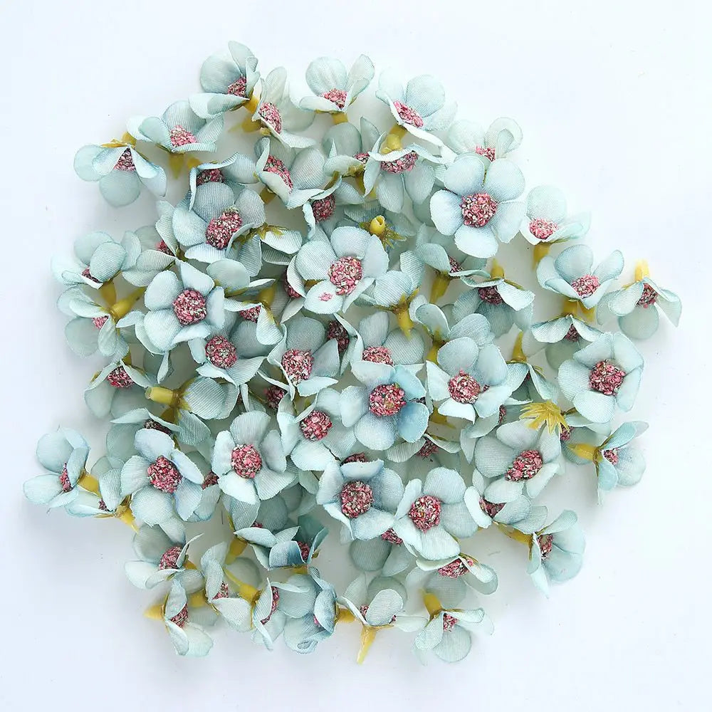 A cluster of light blue and pink silk artificial flower heads used for weddings, crafts, and home decor.
