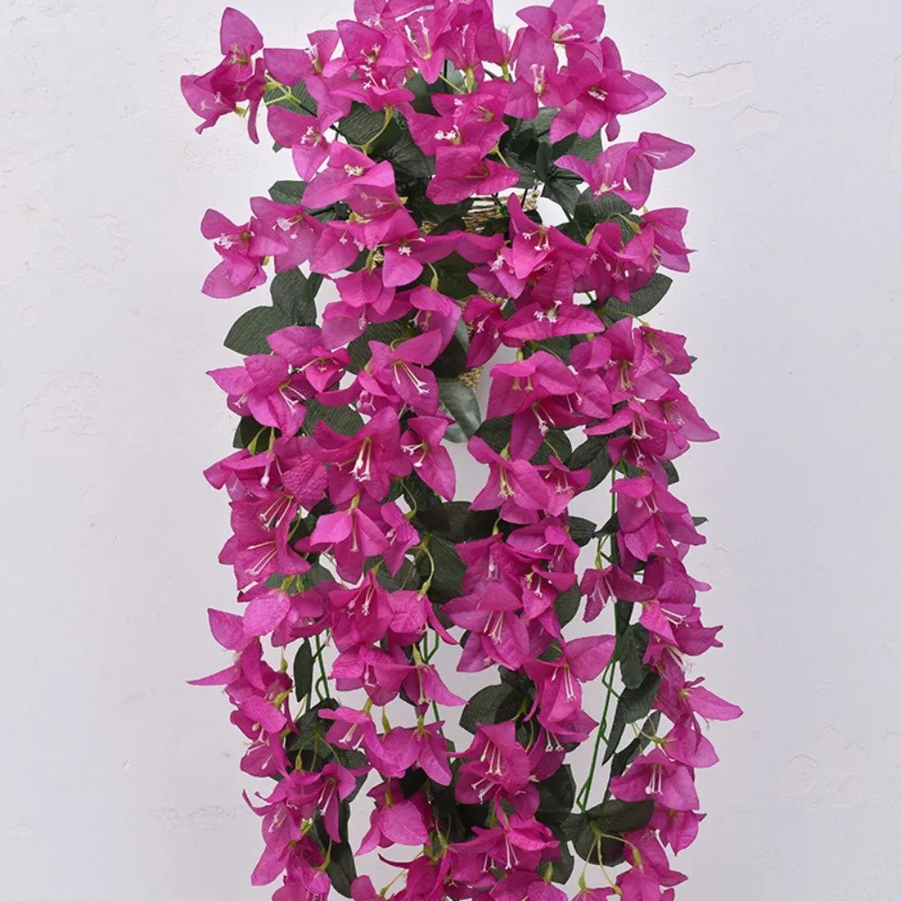 A long, cascading vine of vibrant magenta faux bougainvillea flowers against a white background.
