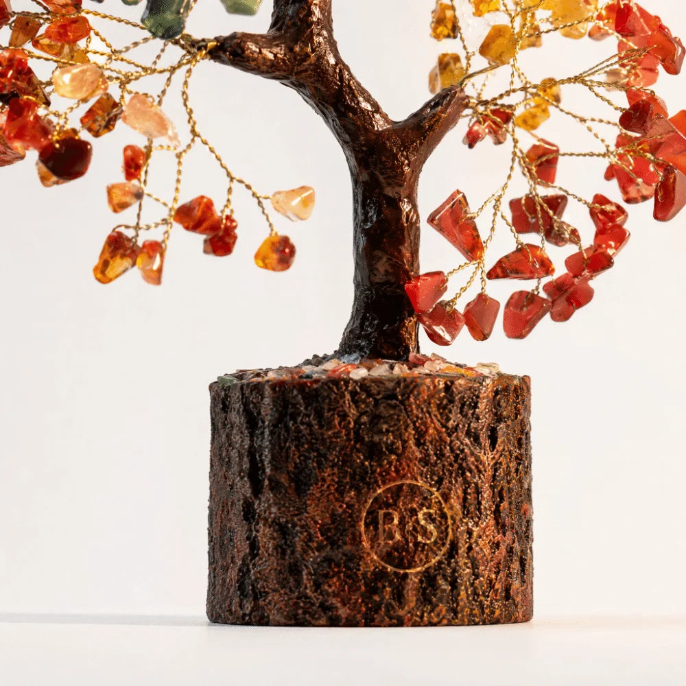 A small, dark wood tree ornament with branches adorned by various colored crystal beads.