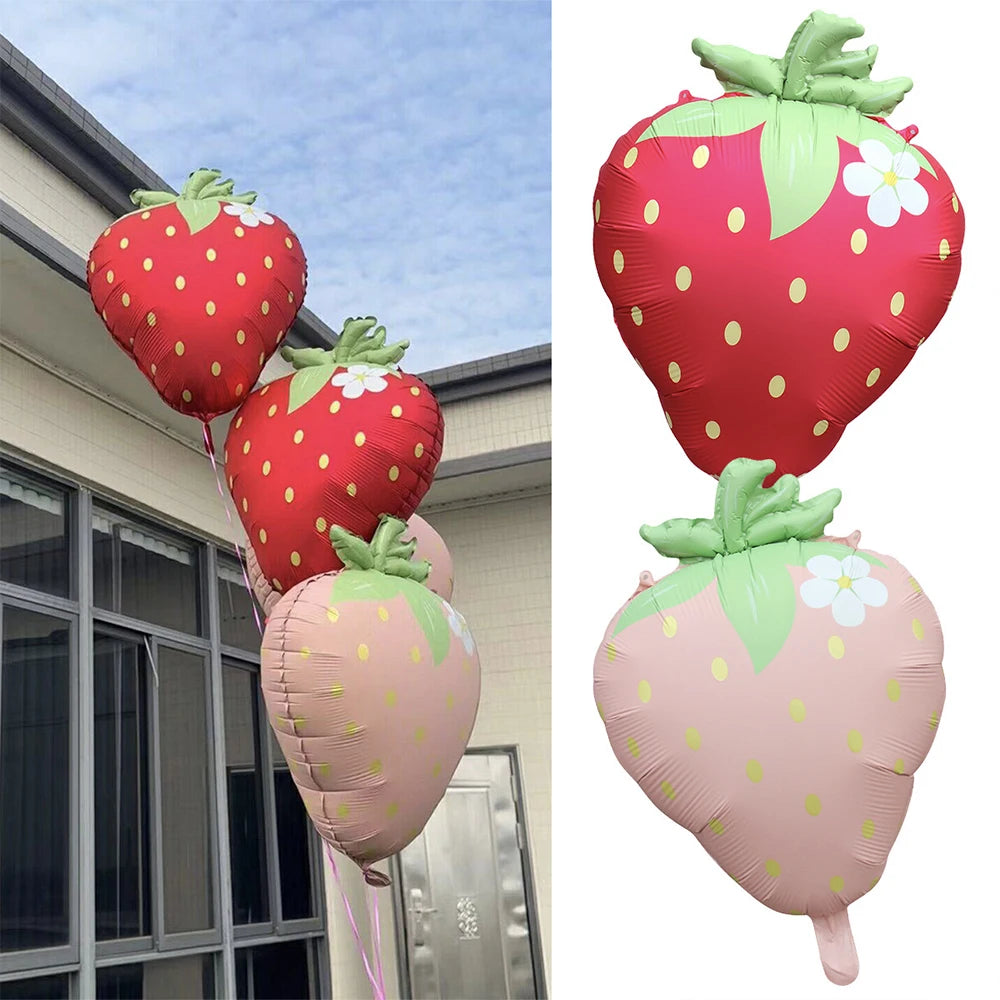 Two pink and red strawberry foil balloons, one large and one small, for party decorations.