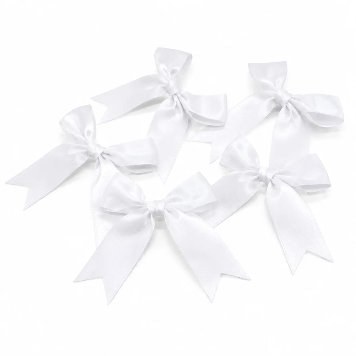 A collection of white satin ribbon bows tied in various decorative styles.
