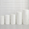 Five cylindrical white spandex covers displayed against a white paneled wall.