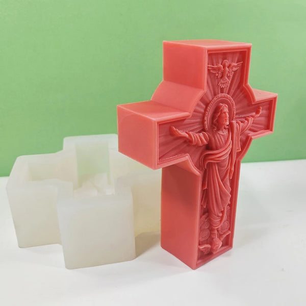 A silicone mold of a religious Jesus cross in coral pink, used for crafting candles.