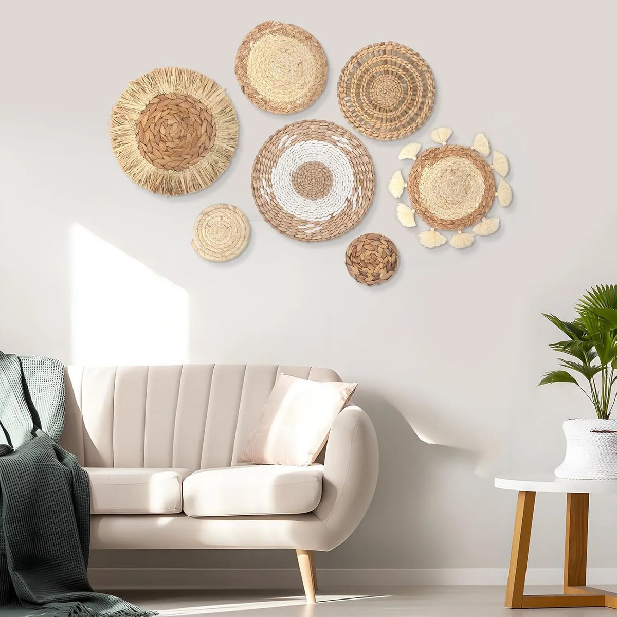 A wall display featuring several round boho straw wall hangings with woven tassels above a light-colored sofa.