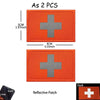 Two orange reflective medical cross patches with a silver cross design and a black loop.