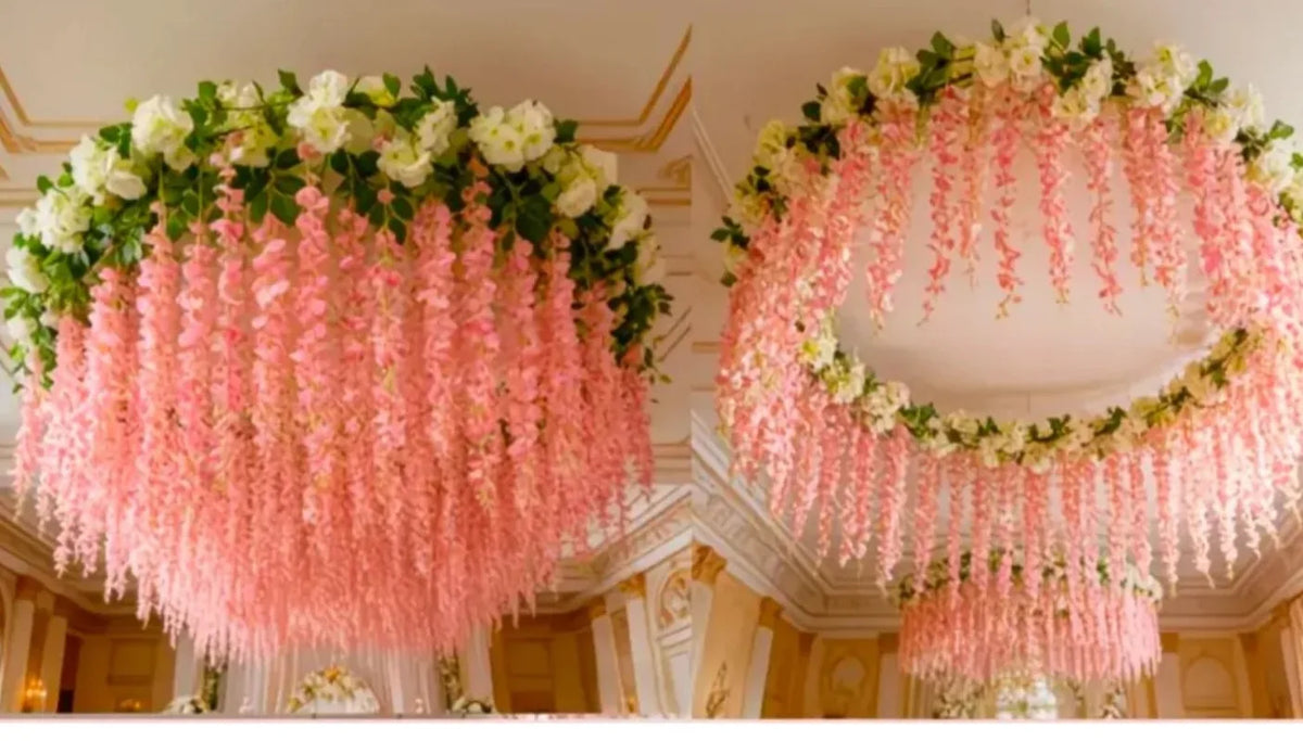 A large floral chandelier featuring pink and white silk wisteria hanging vine garlands in a grand interior setting.
