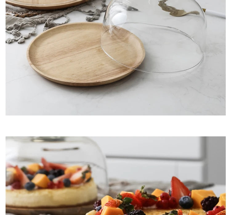 A solid acacia wood cake tray is shown next to a clear glass dome cover on a white marble surface.