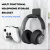 A black headphone storage bracket is shown mounted on a white electronic device.