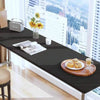 A black table displays a matte peel and stick decor sticker set, a small silver box, and a glass vase with yellow flowers nea