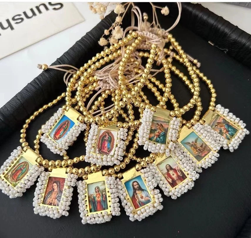 Gold-plated charm bracelet featuring small religious icons and beaded strands