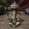 Bronze Ganesha Buddha statue with a crown sitting on a wooden surface.