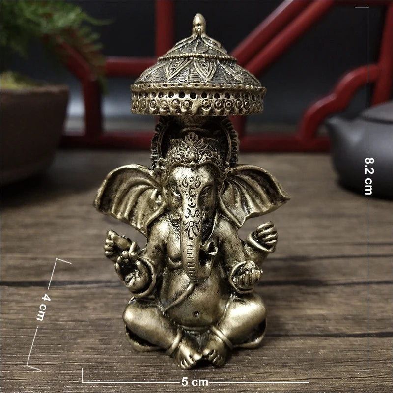 Bronze Ganesha Buddha statue with a crown sitting on a wooden surface.