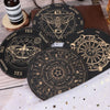 A set of black divination cards featuring celestial symbols and zodiac signs laid out on a wooden surface.