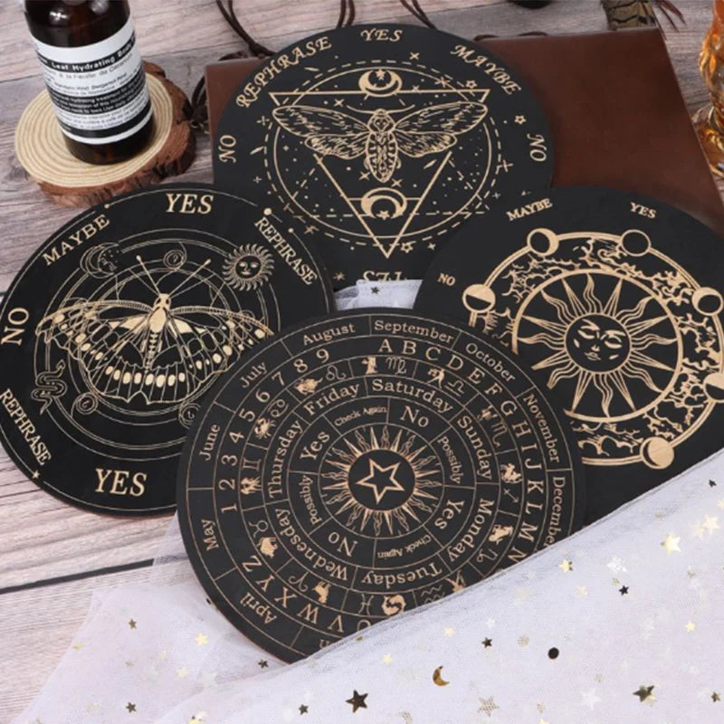 A set of black divination cards featuring celestial symbols and zodiac signs laid out on a wooden surface.