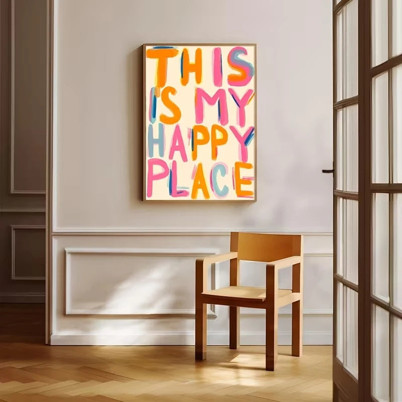 Impresión en lienzo enmarcada con el texto 'Este es mi lugar feliz' en tipografía colorida colgado en una pared blanca.