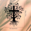 Black silhouette of a tree with roots and a cross carved into a light wall.