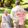 A woman in a light jacket holds a bouquet of handcrafted crochet tulip flowers in pink.