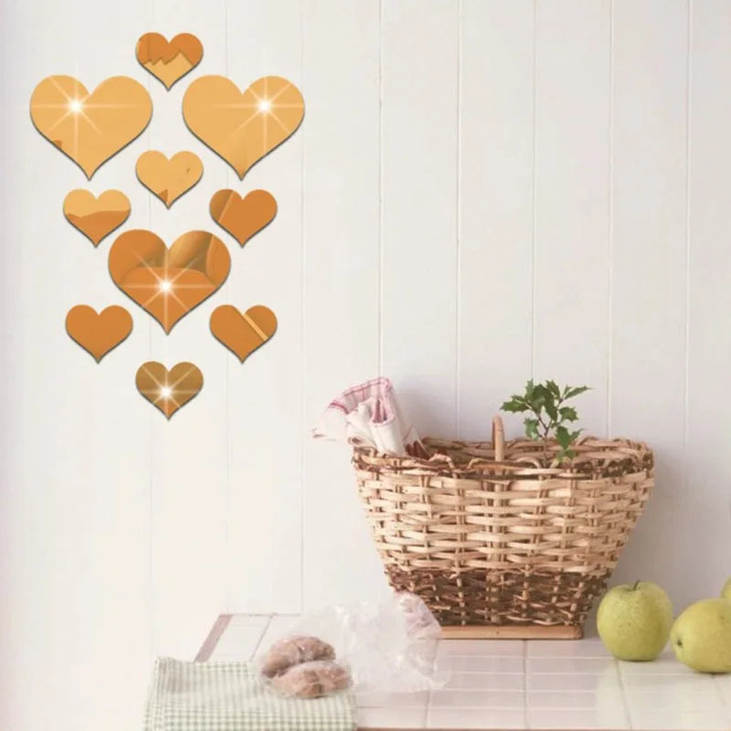 A set of 10 heart-shaped acrylic mirror wall stickers in shades of gold and copper displayed on a white wall.
