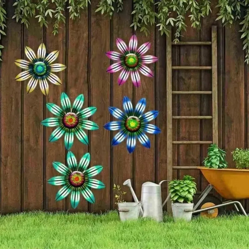 Escultura de pared de flores metálicas coloridas y estilizadas colgadas contra una cerca de madera.
