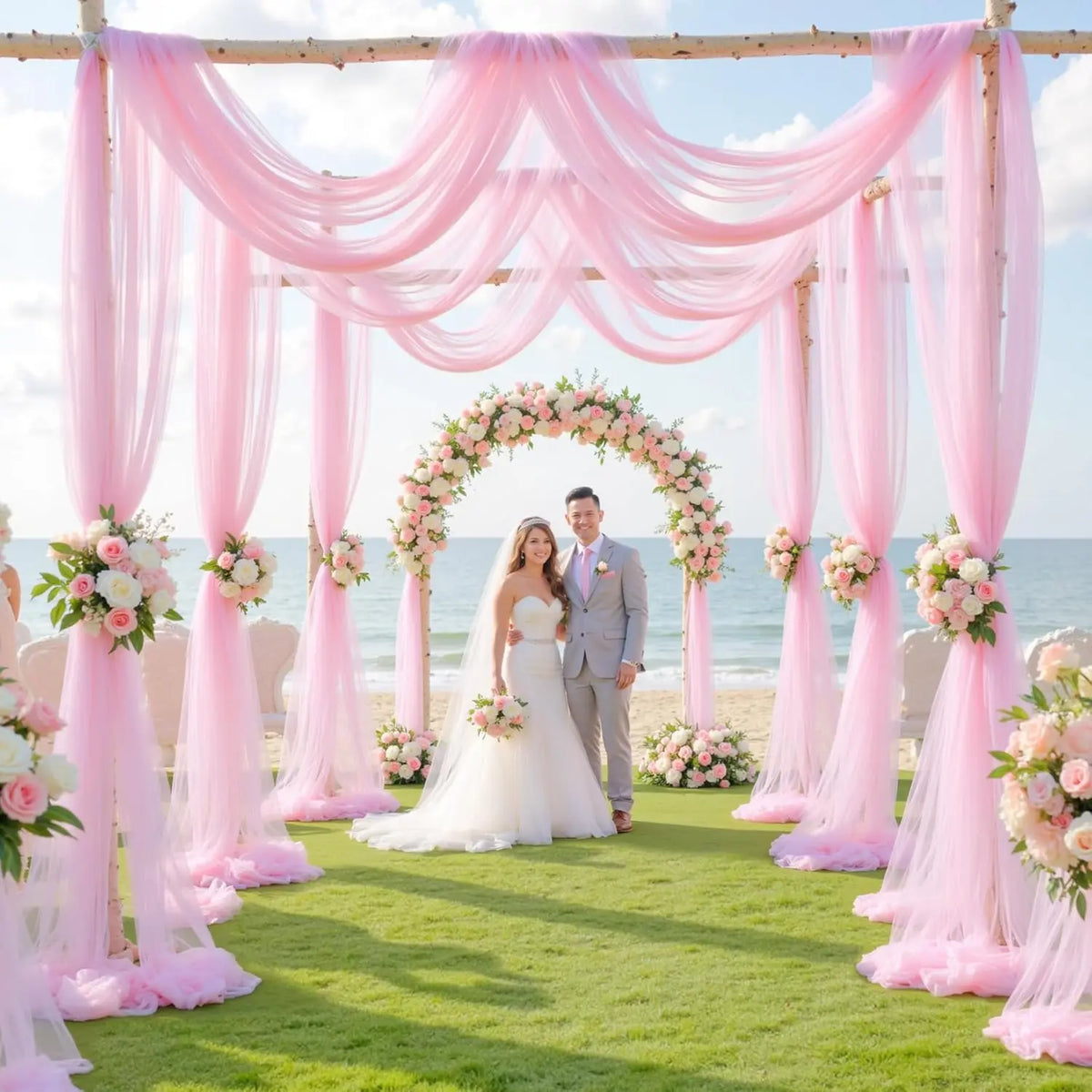 A pink tulle fabric backdrop decorated with floral arches for an elegant wedding ceremony.