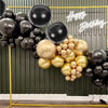 A display of metallic chrome balloons in gold and black colors with Happy Birthday text.