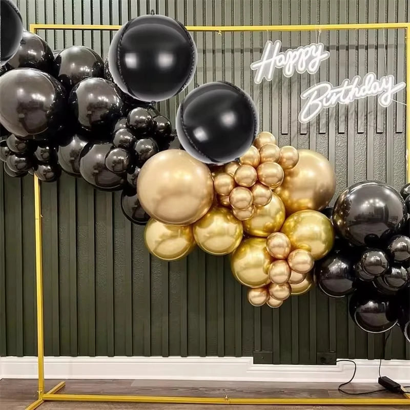 A display of metallic chrome balloons in gold and black colors with Happy Birthday text.