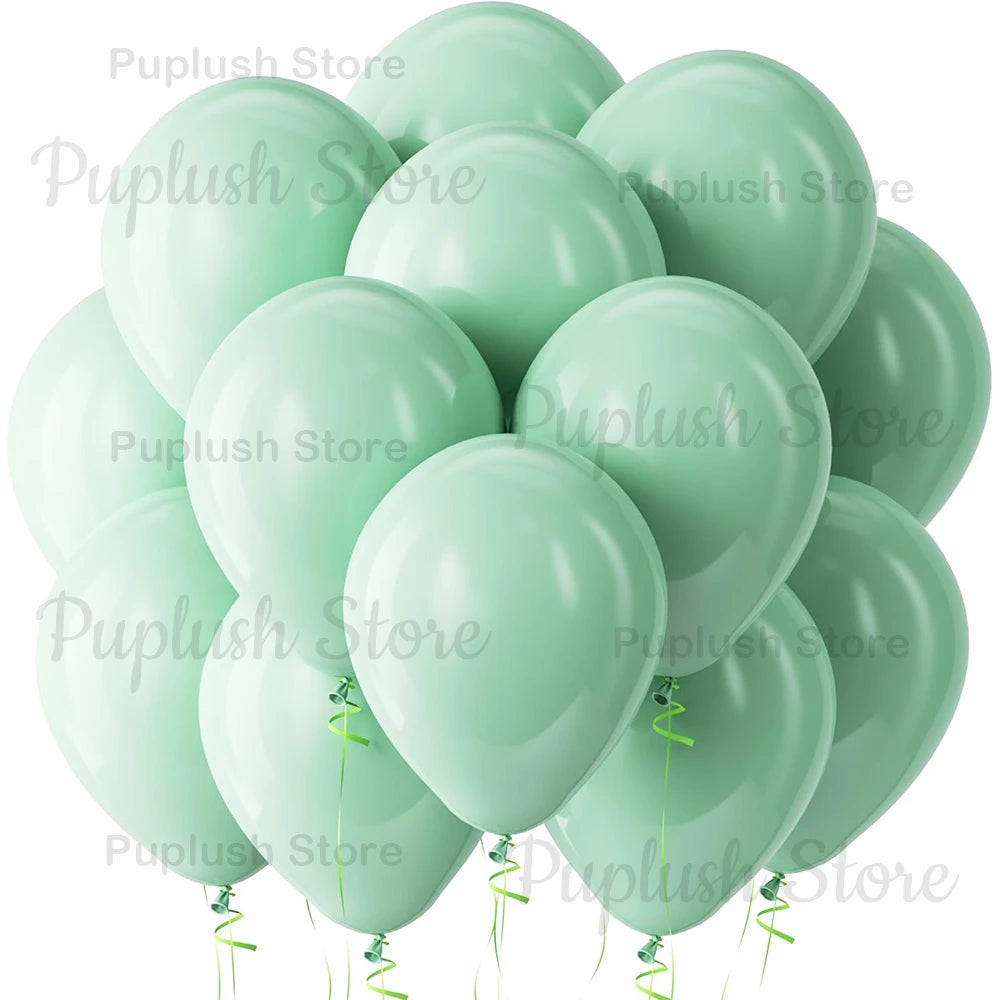A cluster of light sage green latex balloons tied with green ribbons.