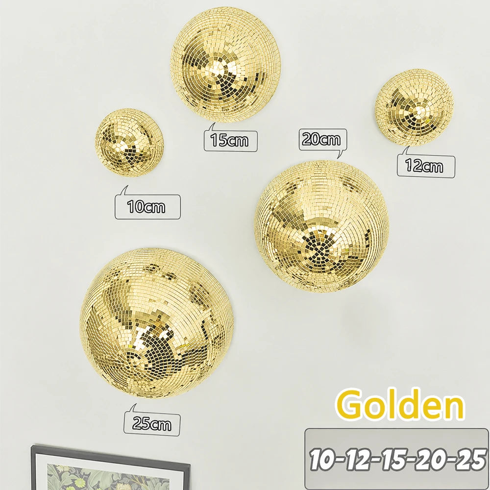 A collection of gold disco balls of various sizes mounted on a white wall.