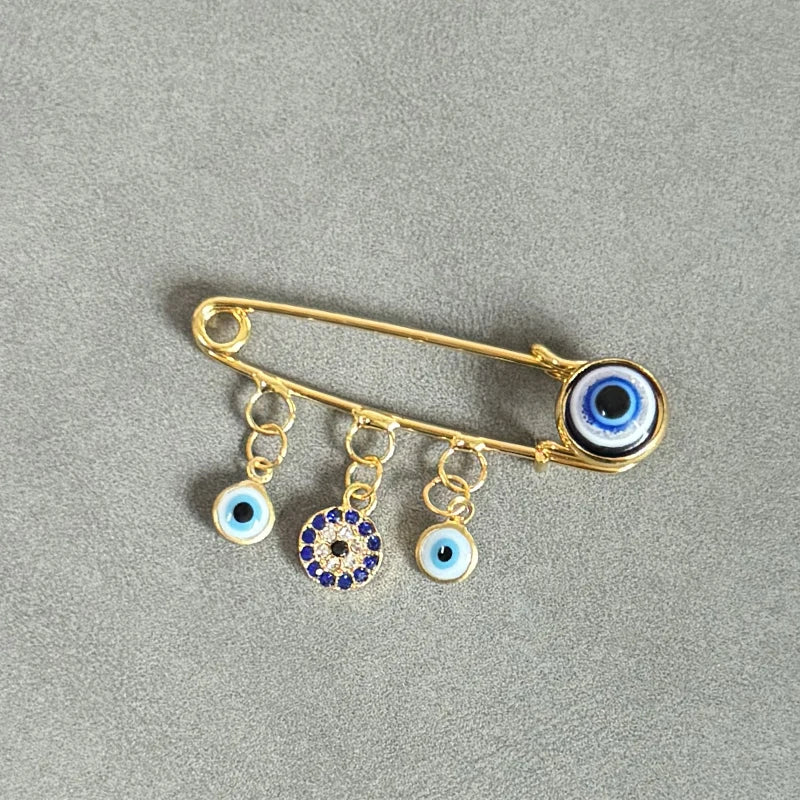 Elegant gold and silver evil eye brooch pin featuring multiple decorative eyes.