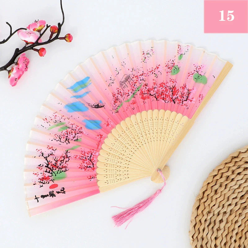 A pink and red vintage silk bamboo folding hand fan with delicate floral designs.