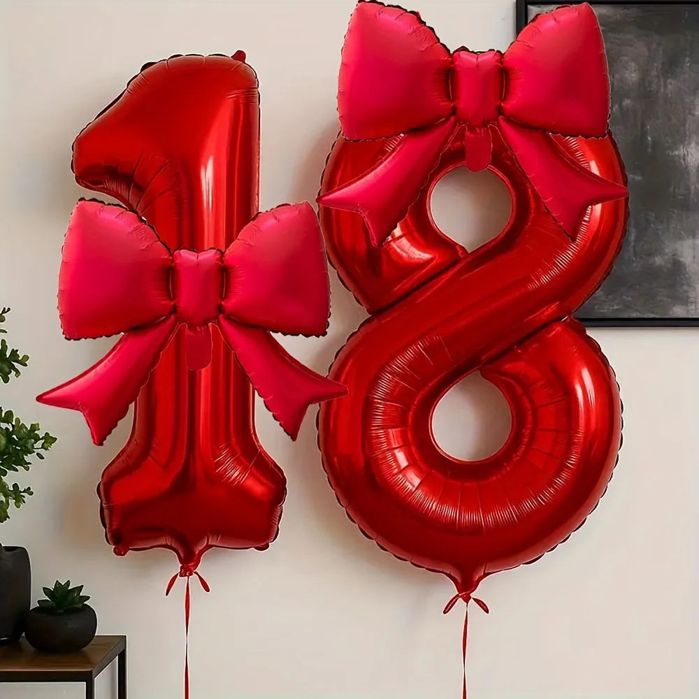 Red foil number balloons shaped like the number 8 with matching pink satin bows
