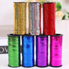A collection of colorful glitter curling ribbon rolls in various shades including gold, silver, red, green, blue, and purple.