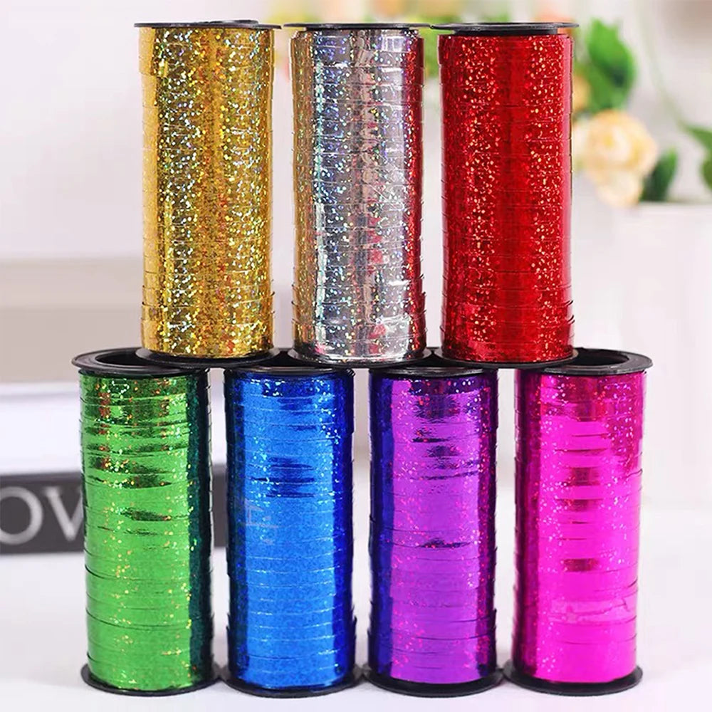 A collection of colorful glitter curling ribbon rolls in various shades including gold, silver, red, green, blue, and purple.