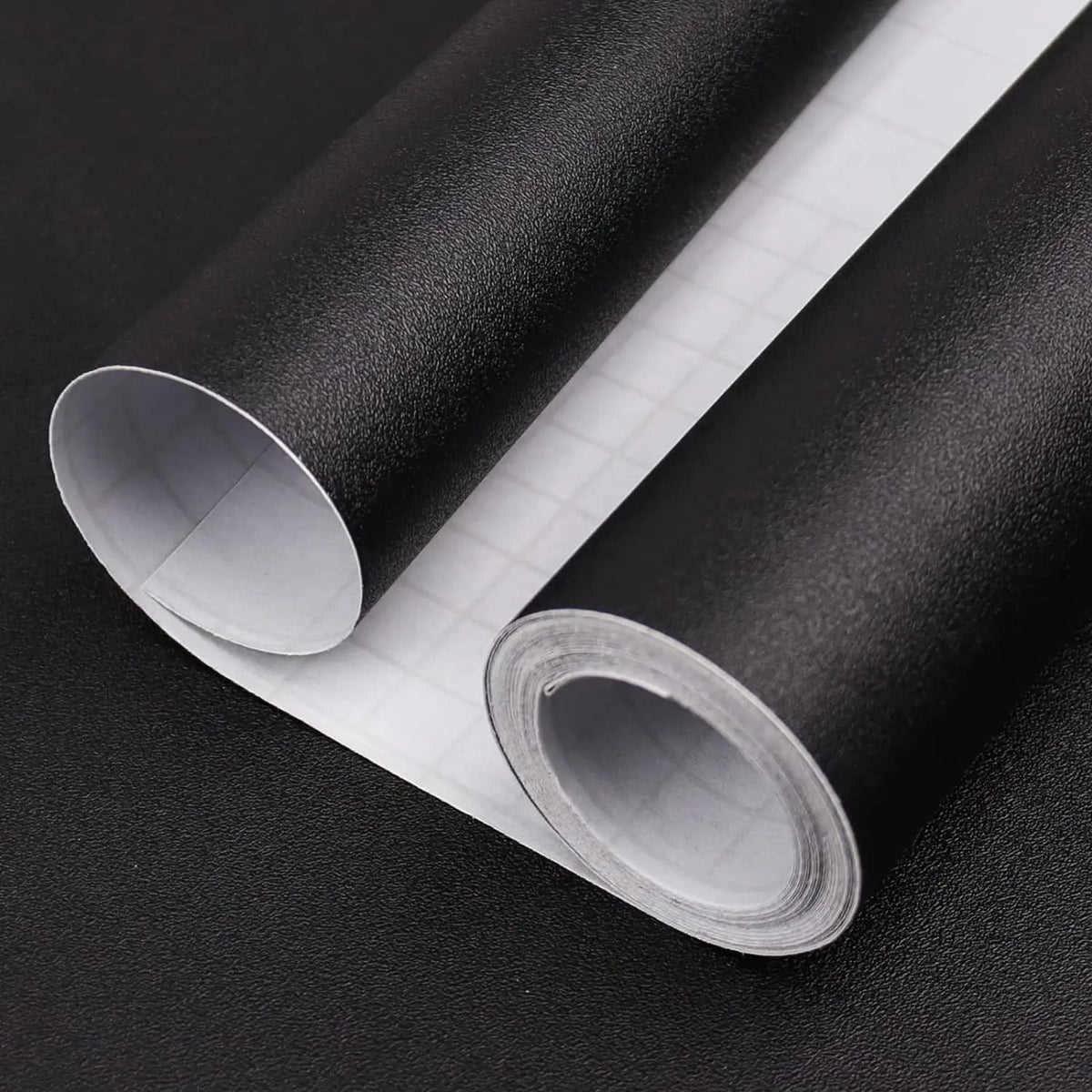 Roll of matte peel and stick decor stickers shown rolled up on a dark surface