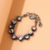 A silver charm bracelet featuring three charms representing Itadori, Fushiguro, and Gojo from Jujutsu Kaisen.