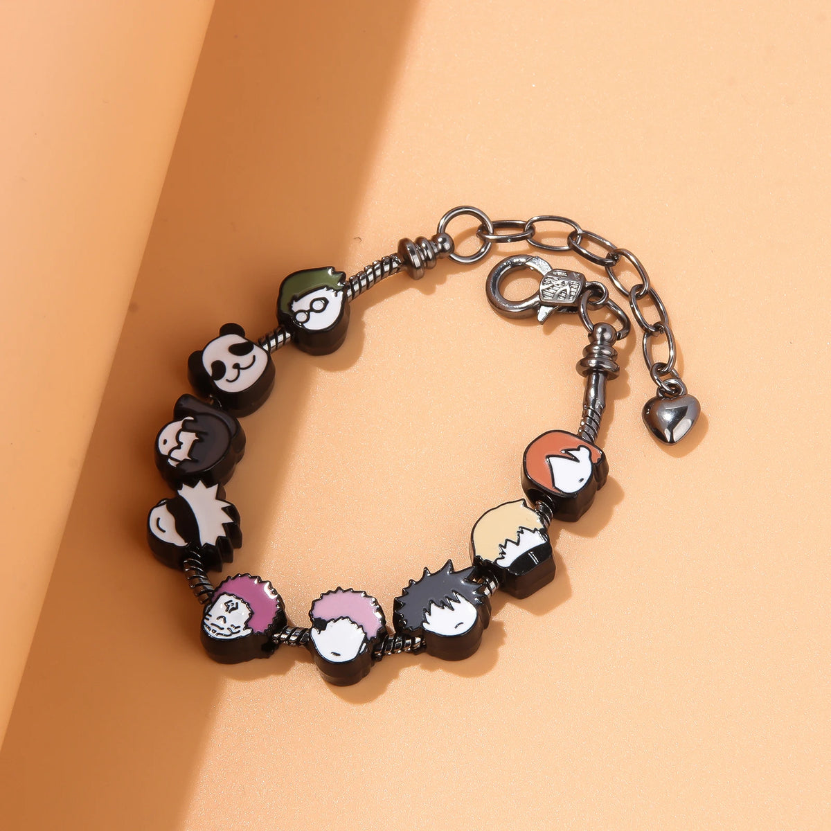 A silver charm bracelet featuring three charms representing Itadori, Fushiguro, and Gojo from Jujutsu Kaisen.